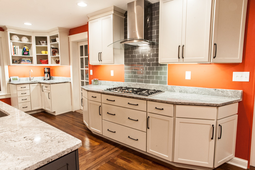 Large transitional u-shaped light wood floor and brown floor enclosed kitchen photo in Baltimore with an undermount sink, shaker cabinets, white cabinets, gray backsplash, subway tile backsplash, stainless steel appliances, an island and quartz countertops