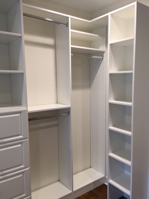 Design ideas for a large traditional gender-neutral walk-in wardrobe in Other with raised-panel cabinets, white cabinets, medium hardwood floors and brown floor.