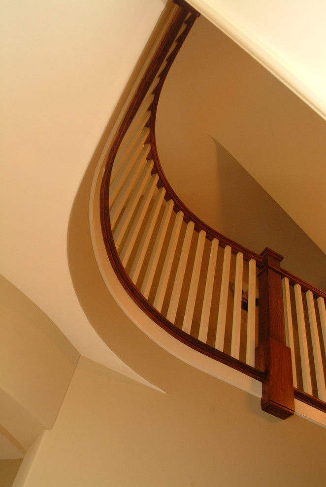 Example of a large transitional medium tone wood floor and brown floor staircase design in Chicago with beige walls