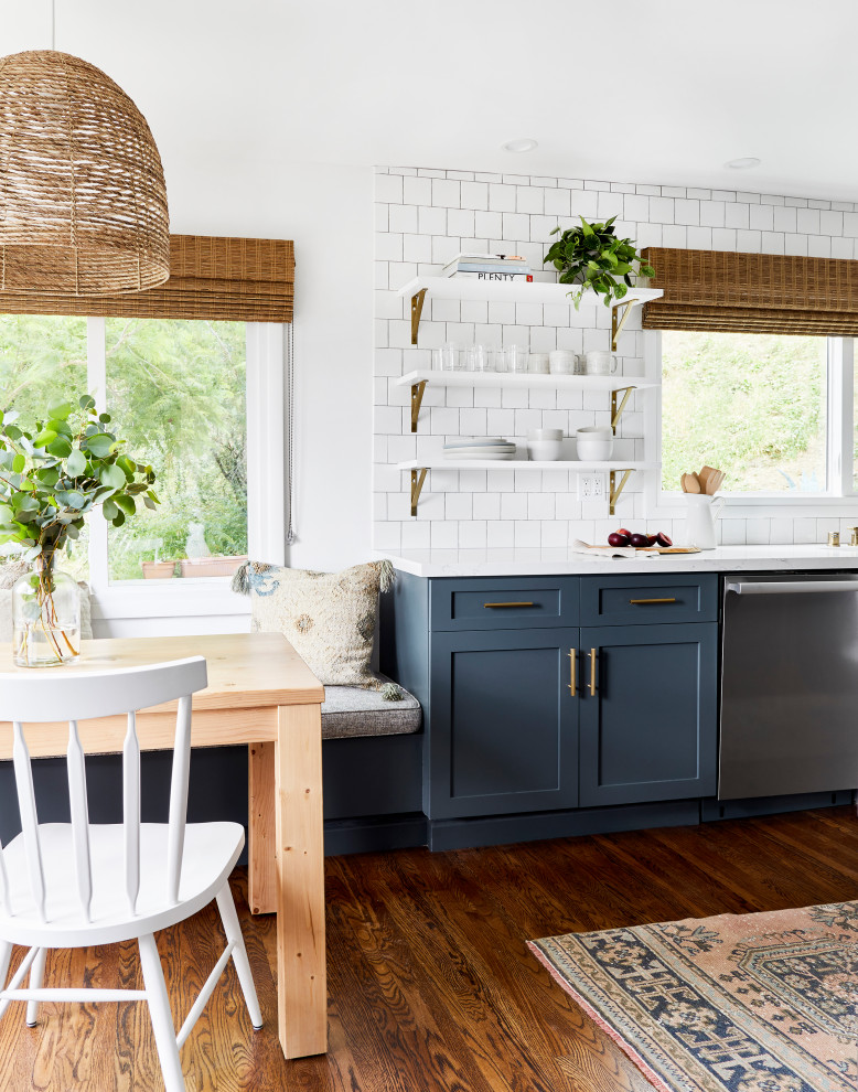 Inspiration for a mid-sized beach style eat-in kitchen in Los Angeles with shaker cabinets, blue cabinets, quartz benchtops, white splashback, subway tile splashback, stainless steel appliances, white benchtop and medium hardwood floors.