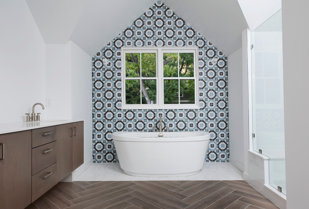 Inspiration for a large transitional master bathroom in Denver with flat-panel cabinets, dark wood cabinets, a freestanding tub, an alcove shower, blue tile, gray tile, cement tile, white walls, vinyl floors, an undermount sink, engineered quartz benchtops, brown floor and a hinged shower door.