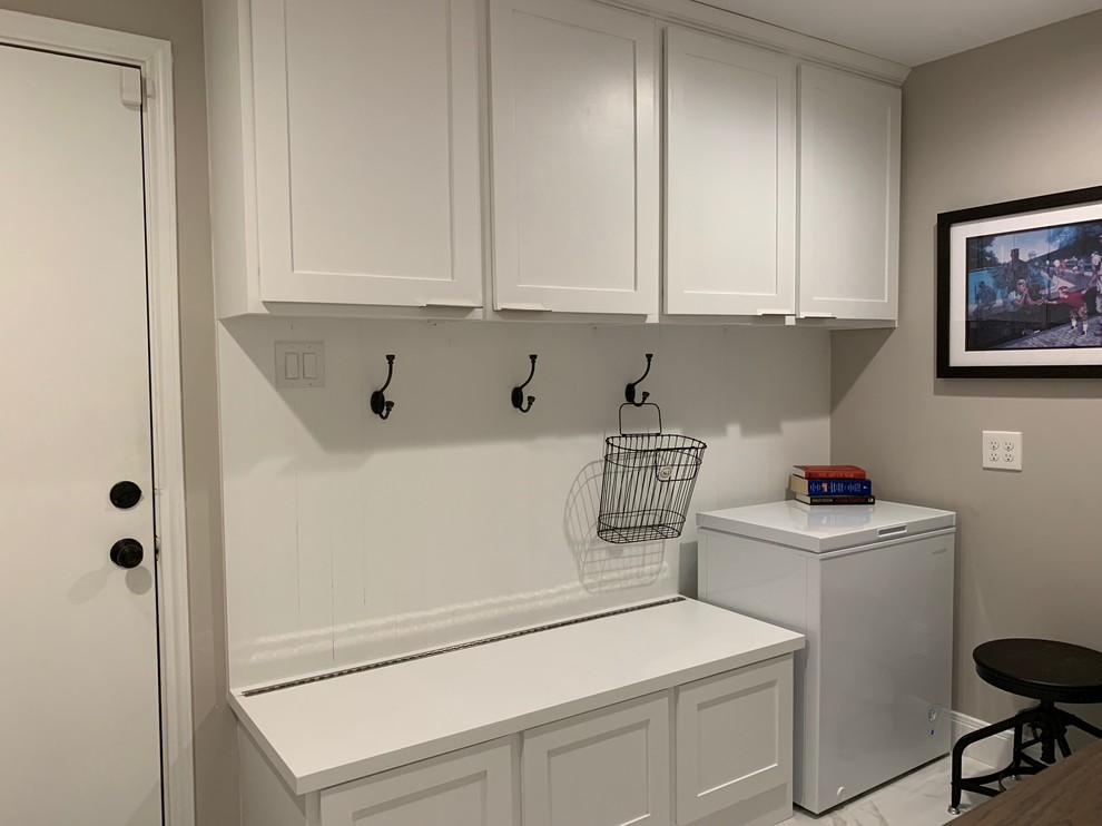 Photo of a small transitional u-shaped utility room in Houston with shaker cabinets, white cabinets, wood benchtops, grey walls, marble floors, a side-by-side washer and dryer, white floor and brown benchtop.