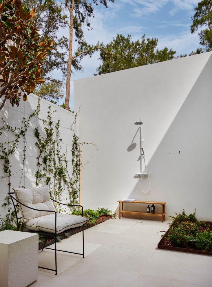 Diseño de patio mediterráneo sin cubierta con ducha exterior y suelo de baldosas