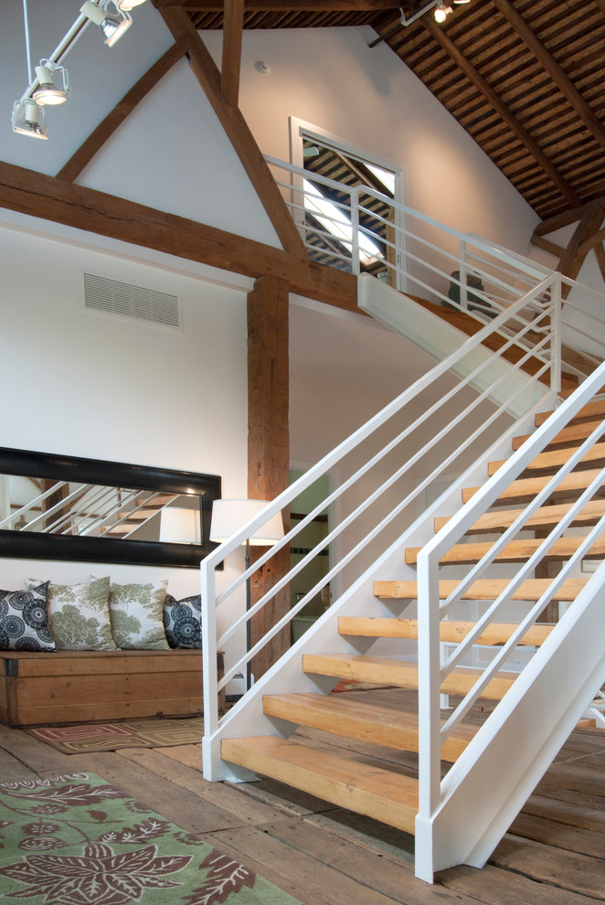 Photo of a large country wood u-shaped staircase in Cleveland with open risers.