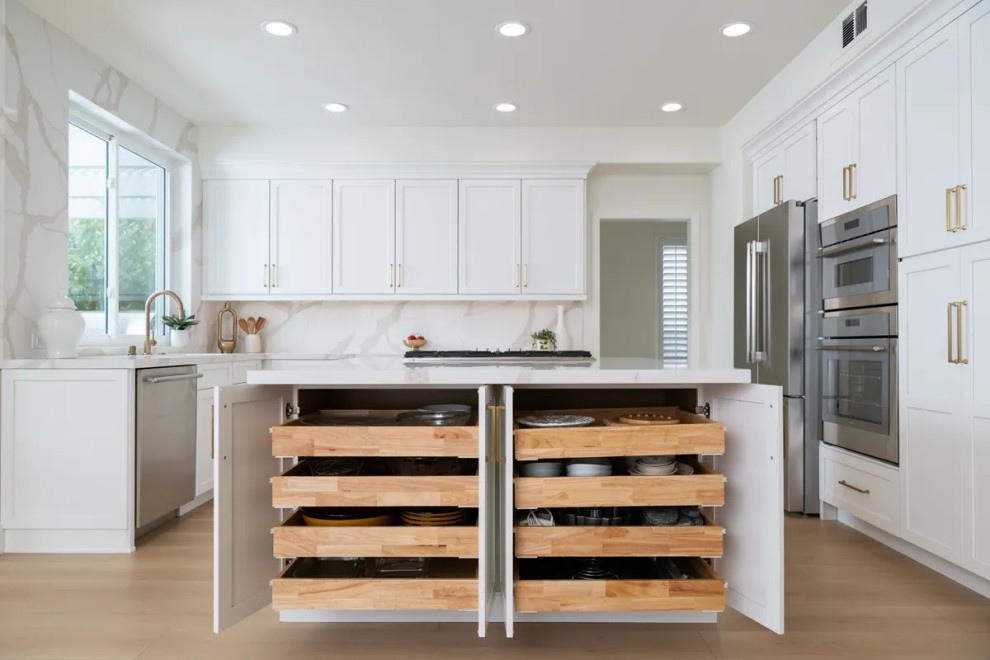 Eat-in kitchen - transitional u-shaped vinyl floor and brown floor eat-in kitchen idea in Orange County with an undermount sink, shaker cabinets, white cabinets, quartz countertops, white backsplash, quartz backsplash, stainless steel appliances, an island and white countertops