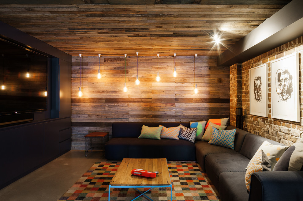 Industrial open concept home theatre in Sydney with multi-coloured walls, concrete floors, a projector screen and grey floor.