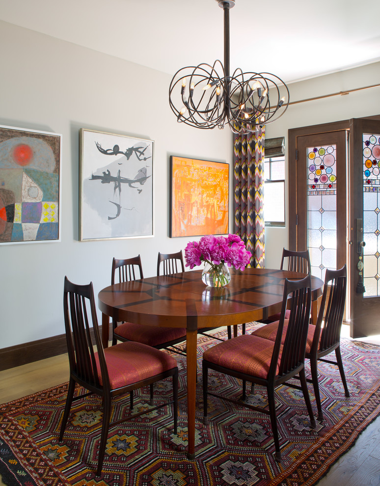 Inspiration for an eclectic dining room in Denver with white walls and light hardwood floors.