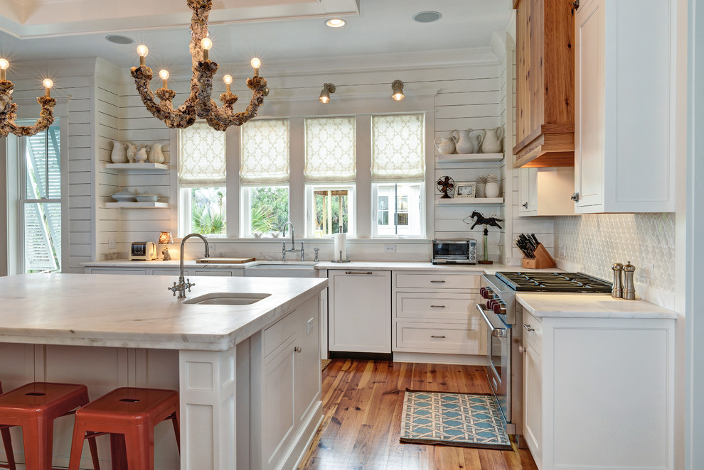 Design ideas for a transitional l-shaped kitchen in Charleston with a farmhouse sink, recessed-panel cabinets, white cabinets, white splashback, stainless steel appliances and marble benchtops.