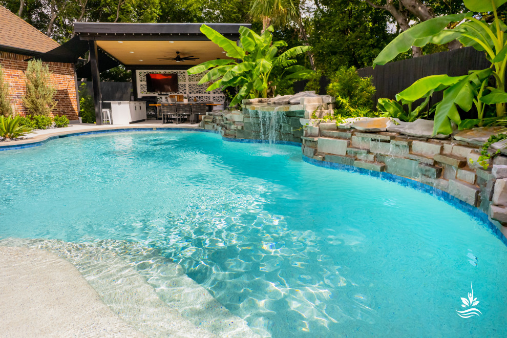 Immagine di un'ampia piscina naturale etnica personalizzata dietro casa con pavimentazioni in pietra naturale
