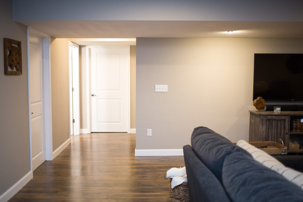 Basement - mid-sized rustic underground medium tone wood floor basement idea in St Louis with beige walls and no fireplace