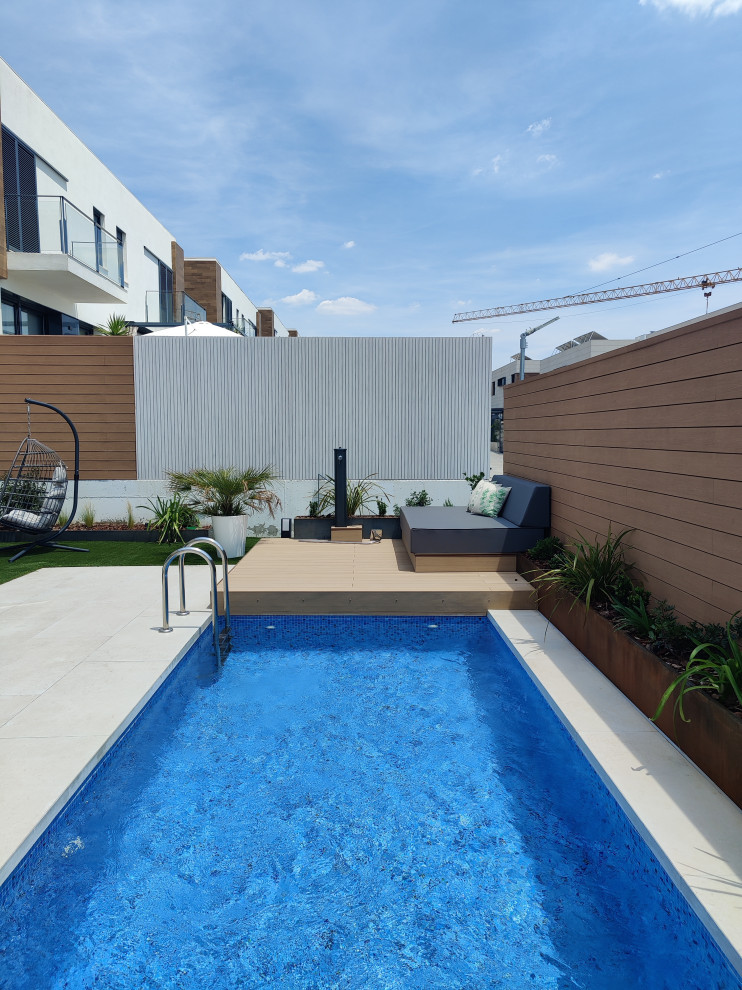 Aménagement d'une piscine arrière moderne de taille moyenne et sur mesure avec une terrasse en bois.