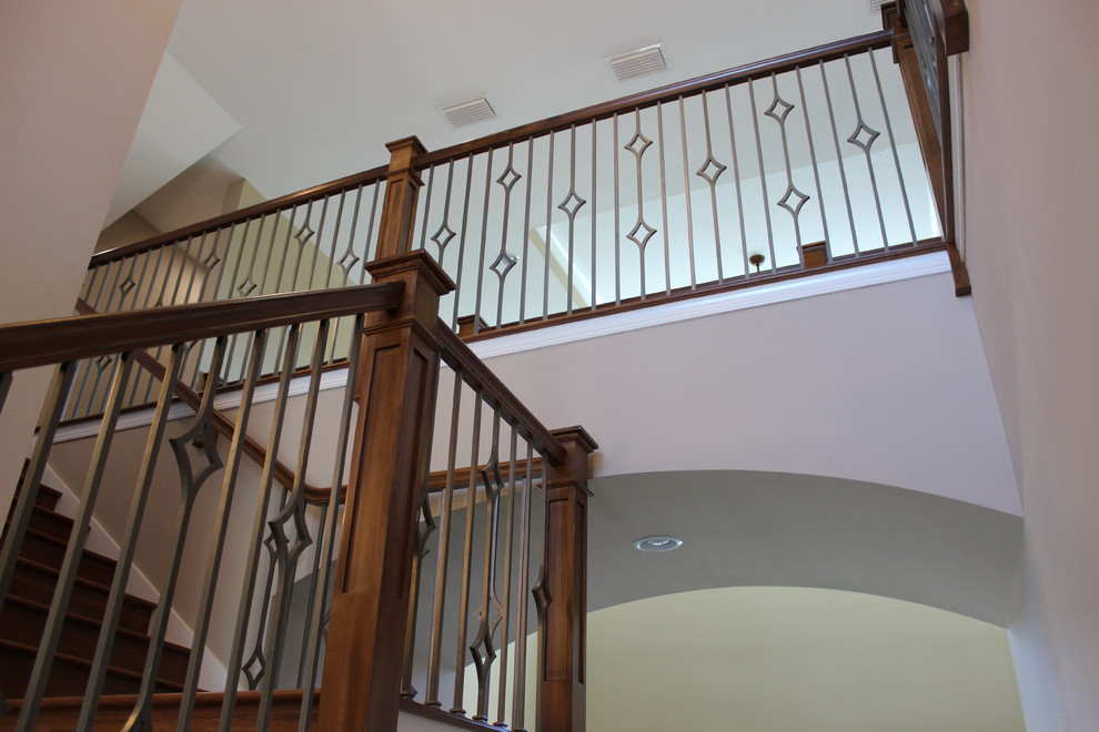 Modelo de escalera en L clásica renovada de tamaño medio con escalones de madera, contrahuellas de madera y barandilla de metal
