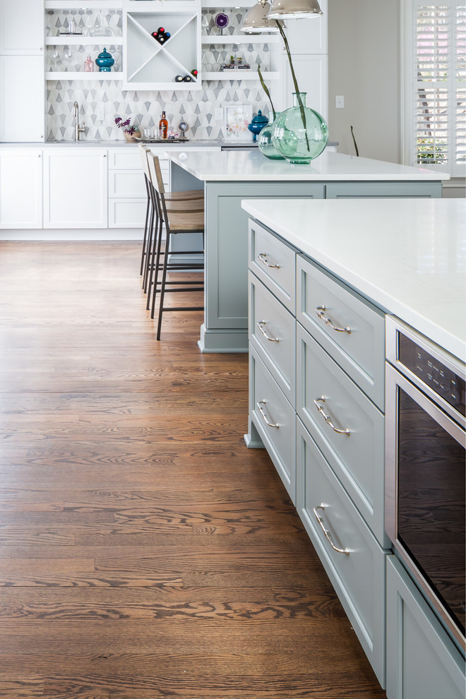 Inspiration for a huge transitional galley medium tone wood floor home design remodel in Raleigh with a farmhouse sink, flat-panel cabinets, white cabinets, quartz countertops, gray backsplash, ceramic backsplash, stainless steel appliances and two islands