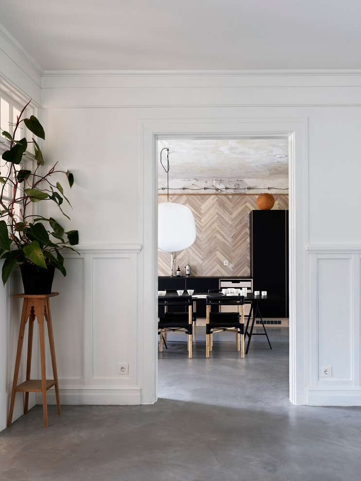 Large traditional dining room in Malmo with white walls and concrete floors.