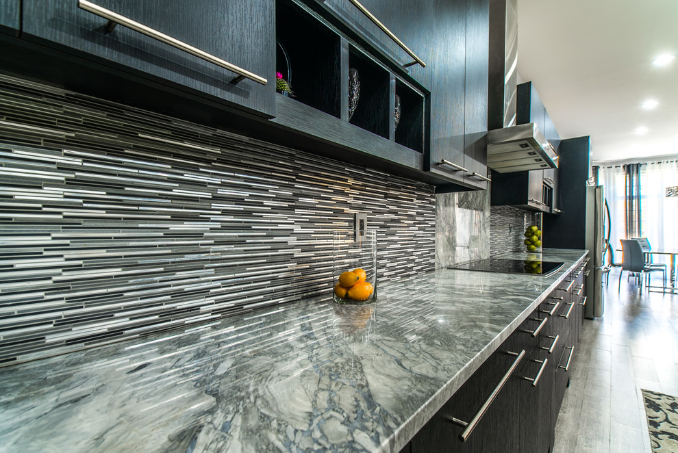 Expansive modern single-wall kitchen pantry in Dallas with a double-bowl sink, flat-panel cabinets, black cabinets, marble benchtops, grey splashback, glass tile splashback, stainless steel appliances, ceramic floors, with island and grey floor.