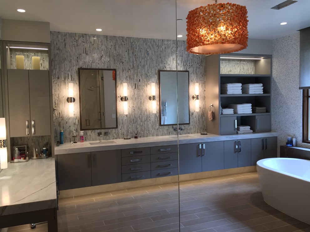 This is an example of a large contemporary master bathroom in San Francisco with an undermount sink, flat-panel cabinets, grey cabinets, marble benchtops, a freestanding tub, a curbless shower, a one-piece toilet, brown tile, porcelain tile, white walls and porcelain floors.