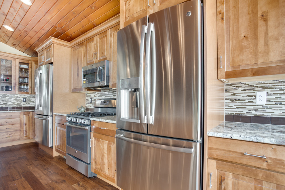 Kitchen - large rustic kitchen idea in DC Metro with an undermount sink, raised-panel cabinets, granite countertops, glass tile backsplash, stainless steel appliances and an island