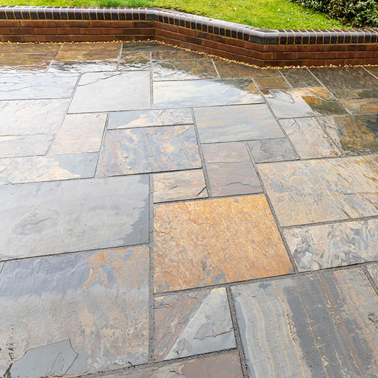 Design ideas for a medium sized classic back patio in Hertfordshire with natural stone paving.