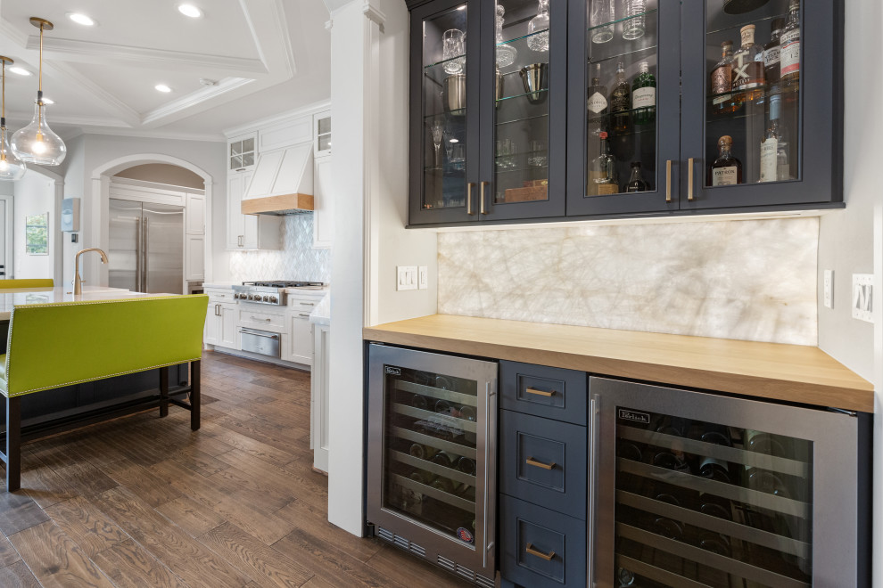 Example of a large transitional single-wall light wood floor and brown floor eat-in kitchen design in Houston with a farmhouse sink, recessed-panel cabinets, white cabinets, quartzite countertops, white backsplash, mosaic tile backsplash, stainless steel appliances, an island and white countertops