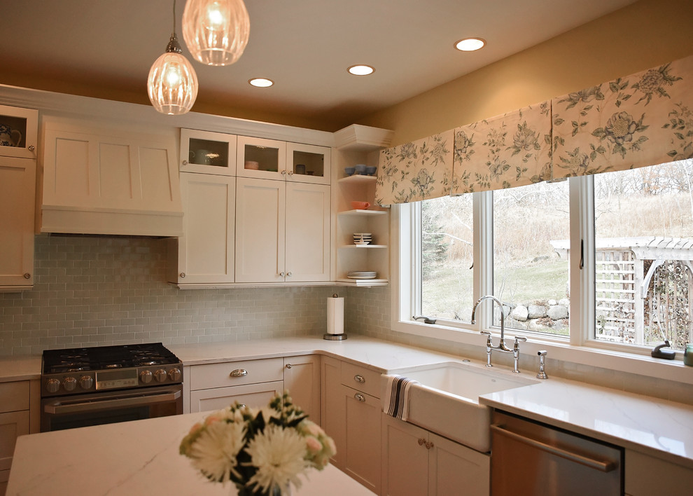 Mid-sized transitional u-shaped medium tone wood floor and brown floor eat-in kitchen photo with an undermount sink, flat-panel cabinets, white cabinets, quartz countertops, blue backsplash, ceramic backsplash, stainless steel appliances, an island and white countertops