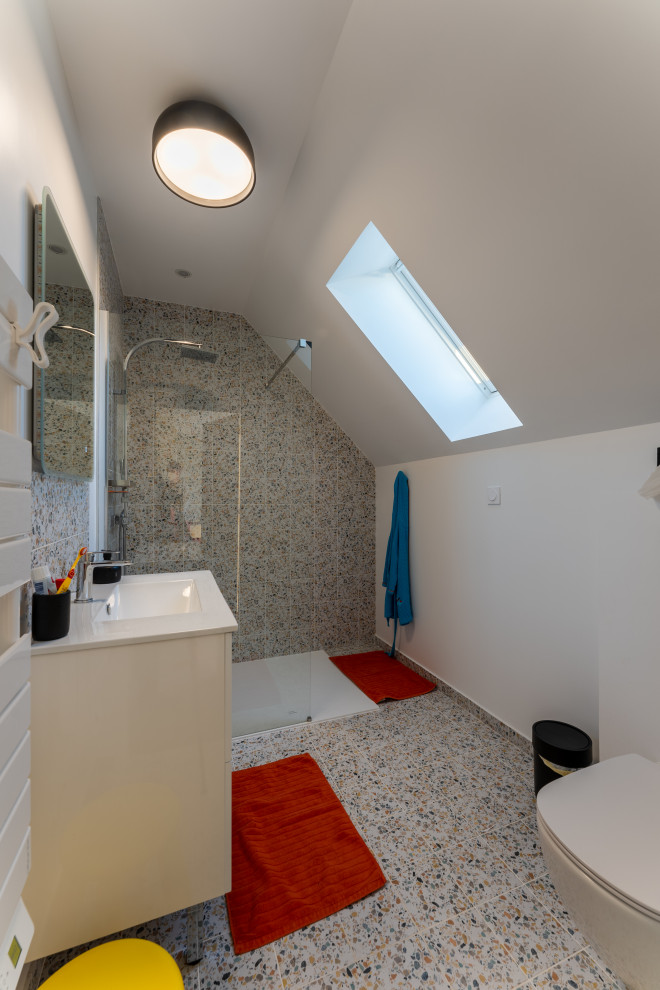 Small eclectic shower room bathroom in Paris with beaded cabinets, white cabinets, an alcove shower, a wall mounted toilet, multi-coloured tiles, ceramic tiles, white walls, ceramic flooring, a built-in sink, laminate worktops, grey floors, a sliding door, white worktops, a single sink and a floating vanity unit.