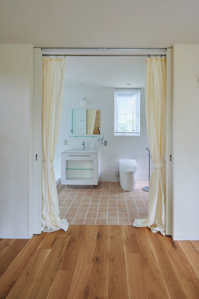 Пример оригинального дизайна: главная ванная комната среднего размера в скандинавском стиле с открытыми фасадами, белыми фасадами, полом из терракотовой плитки, коричневым полом и встроенной тумбой