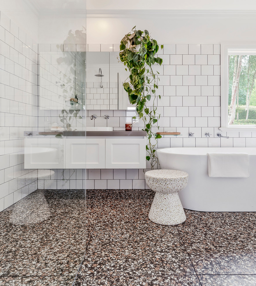 Mid-sized contemporary master bathroom in Melbourne with shaker cabinets, white cabinets, a freestanding tub, a curbless shower, white tile, white walls, terrazzo floors, a drop-in sink, engineered quartz benchtops, an open shower, grey benchtops and multi-coloured floor.