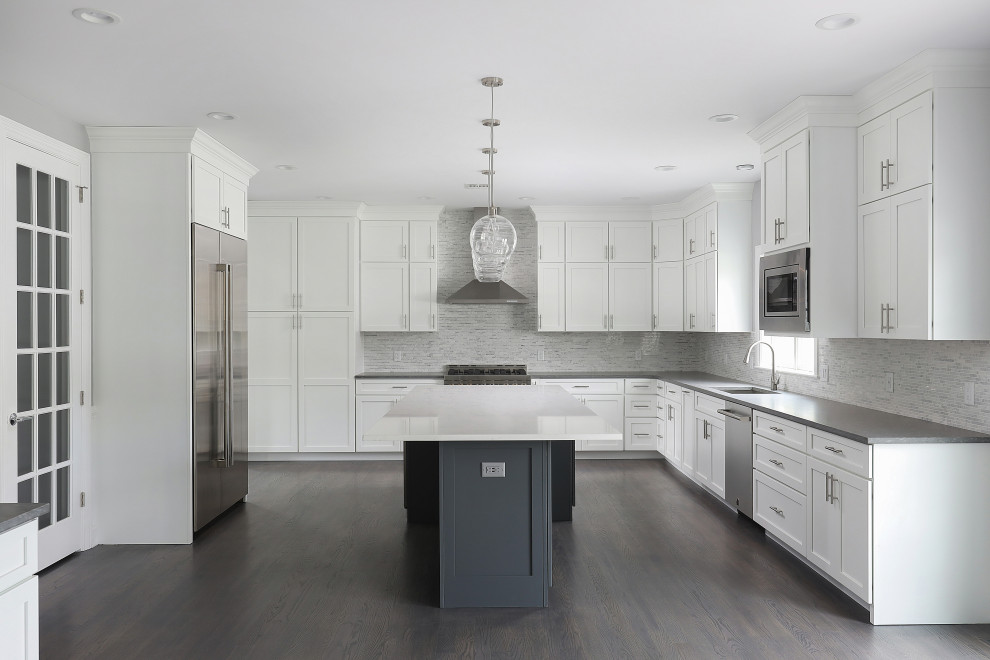 Immagine di una grande cucina classica con lavello sottopiano, ante in stile shaker, ante bianche, elettrodomestici in acciaio inossidabile e pavimento marrone