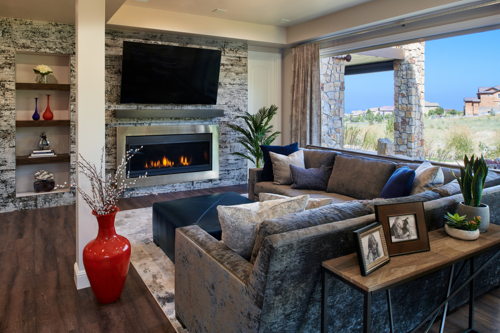 Photo of a large transitional open concept family room in Denver with a standard fireplace, a tile fireplace surround, a wall-mounted tv and brown floor.
