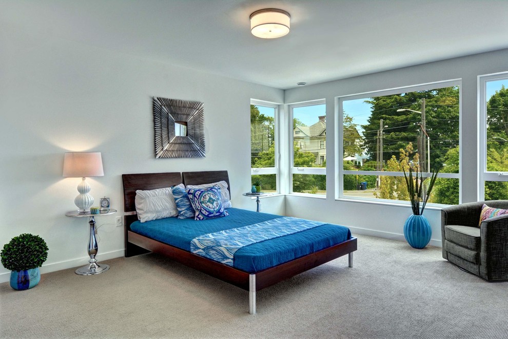 This is an example of a contemporary bedroom in Seattle with white walls and carpet.