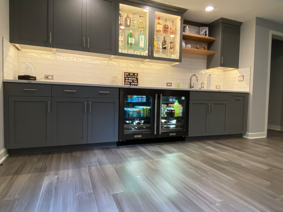 Photo of a mid-sized traditional walk-out basement in Atlanta with a home bar, bamboo floors and grey floor.