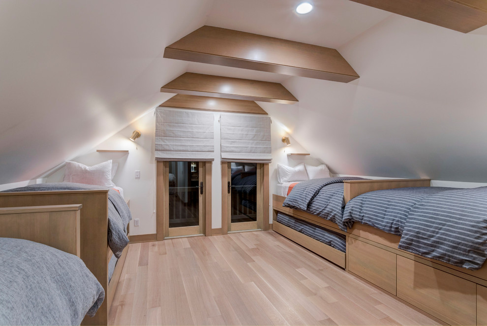 This is an example of a mid-sized contemporary guest bedroom in Portland with white walls and light hardwood floors.
