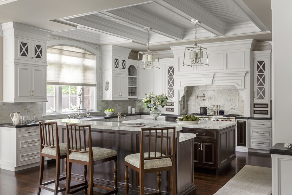 Inspiration for a large traditional l-shaped kitchen in San Francisco with a farmhouse sink, recessed-panel cabinets, white cabinets, marble benchtops, stainless steel appliances, dark hardwood floors, with island, brown floor and white splashback.