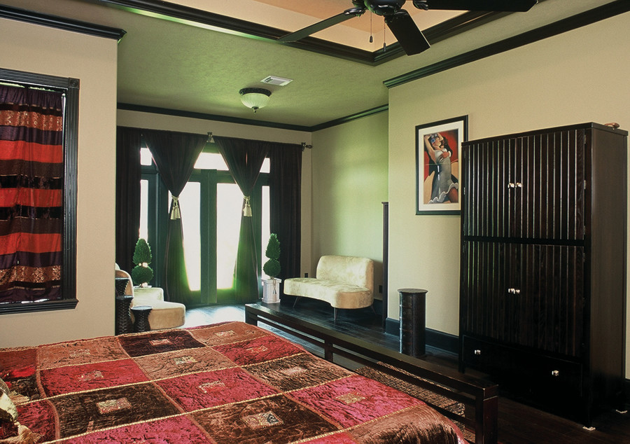 Inspiration for a large traditional master bedroom in Houston with green walls and dark hardwood floors.