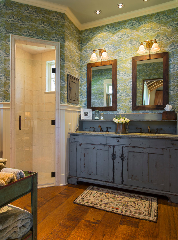 Large mountain style master medium tone wood floor corner shower photo in Austin with distressed cabinets and multicolored walls