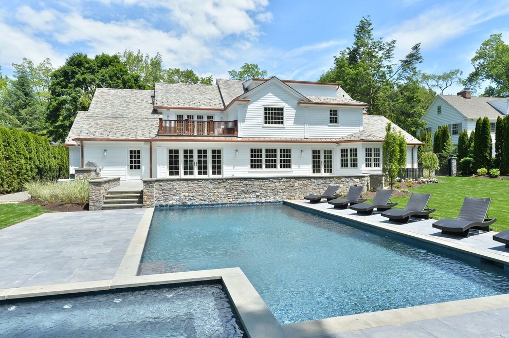 Example of a large transitional backyard stone and rectangular lap hot tub design in New York