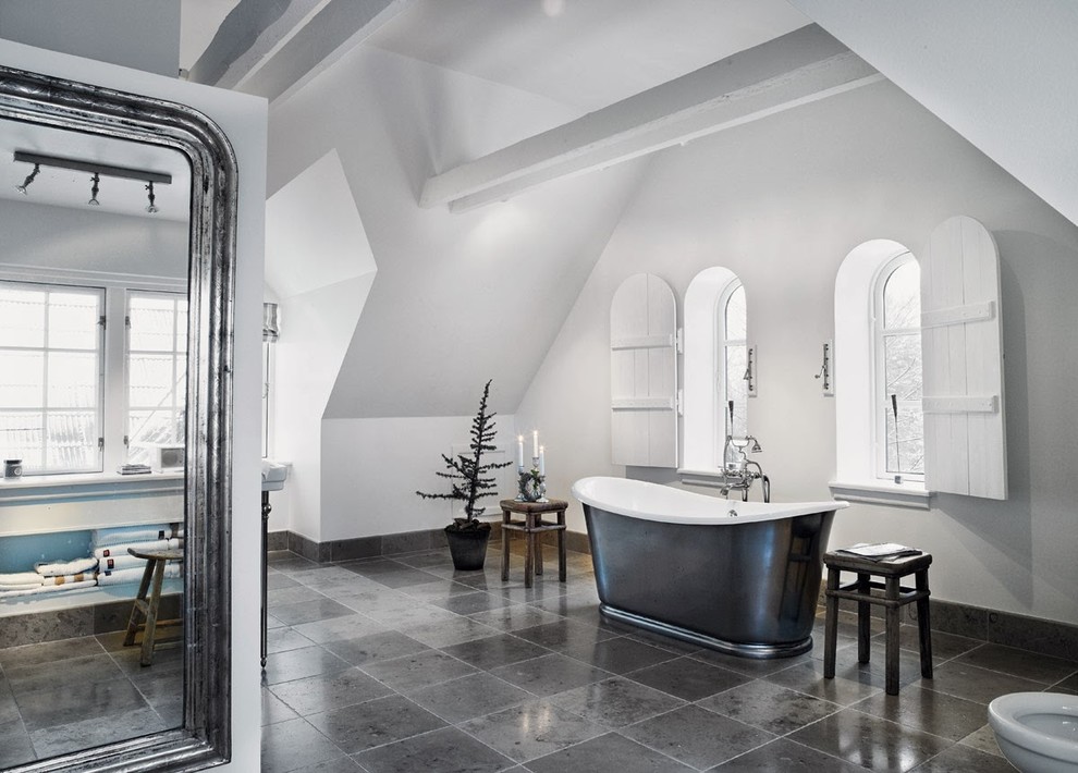 Example of a transitional master freestanding bathtub design in DC Metro with gray walls