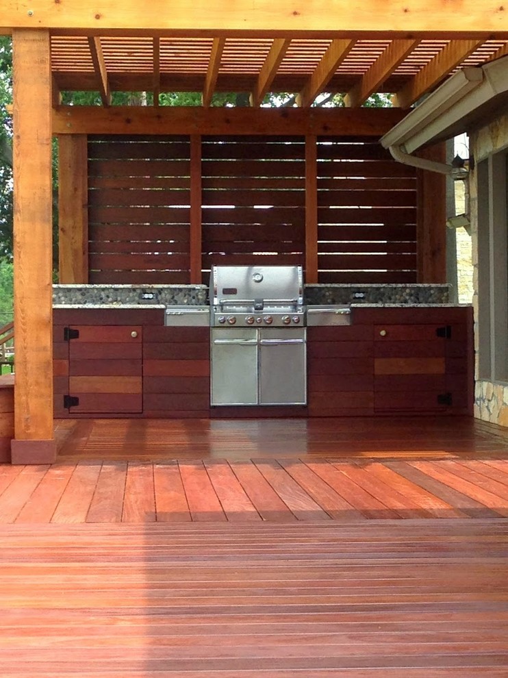 This is an example of a large contemporary backyard deck in Dallas with an outdoor kitchen and a pergola.