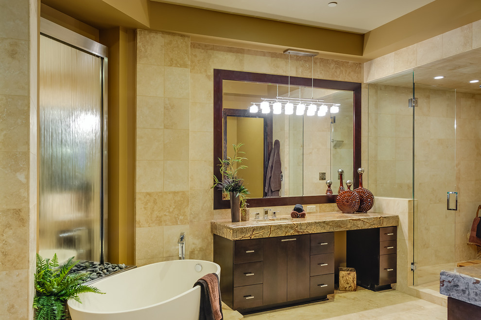 This is an example of a large contemporary master bathroom in Portland with an undermount sink, flat-panel cabinets, dark wood cabinets, marble benchtops, a freestanding tub, a double shower, beige tile, stone tile, beige walls and travertine floors.