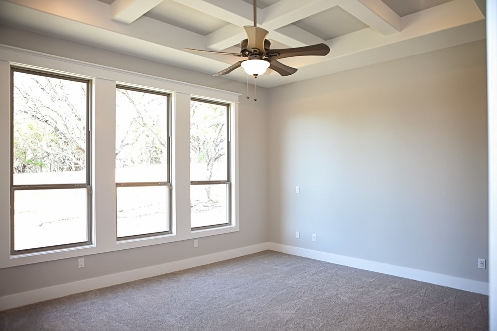 Photo of a large arts and crafts master bedroom in Austin with grey walls and concrete floors.
