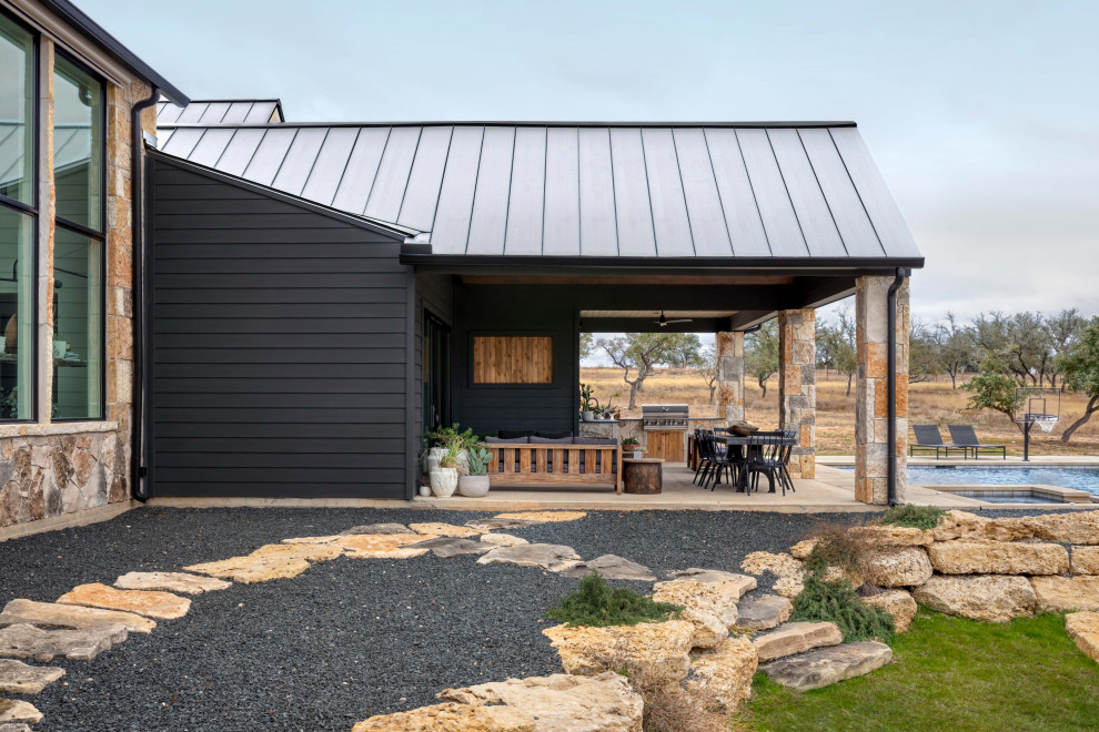 Inspiration pour une terrasse arrière rustique avec une cuisine d'été, une dalle de béton et une extension de toiture.