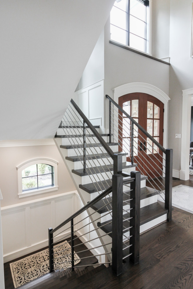 Large contemporary wood u-shaped staircase in DC Metro with wood risers and mixed railing.