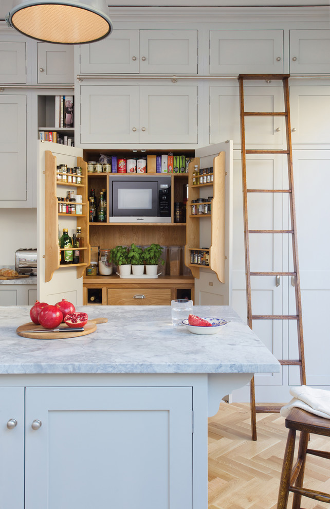 Inspiration for a traditional kitchen pantry in Surrey with shaker cabinets and with island.