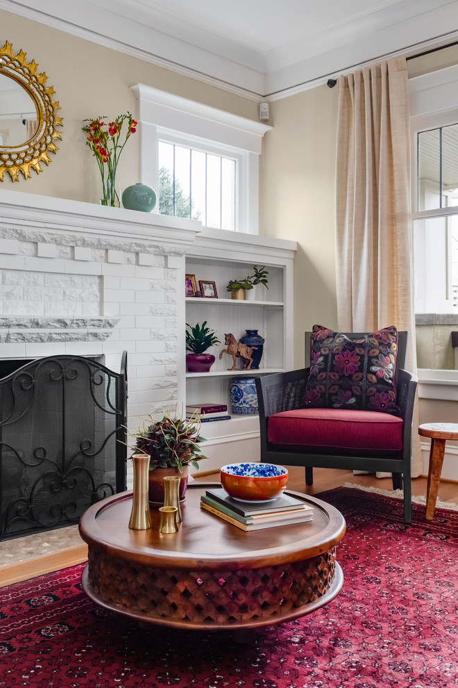 This is an example of a mid-sized eclectic enclosed living room in Seattle with beige walls, light hardwood floors, a standard fireplace, a brick fireplace surround, no tv and brown floor.