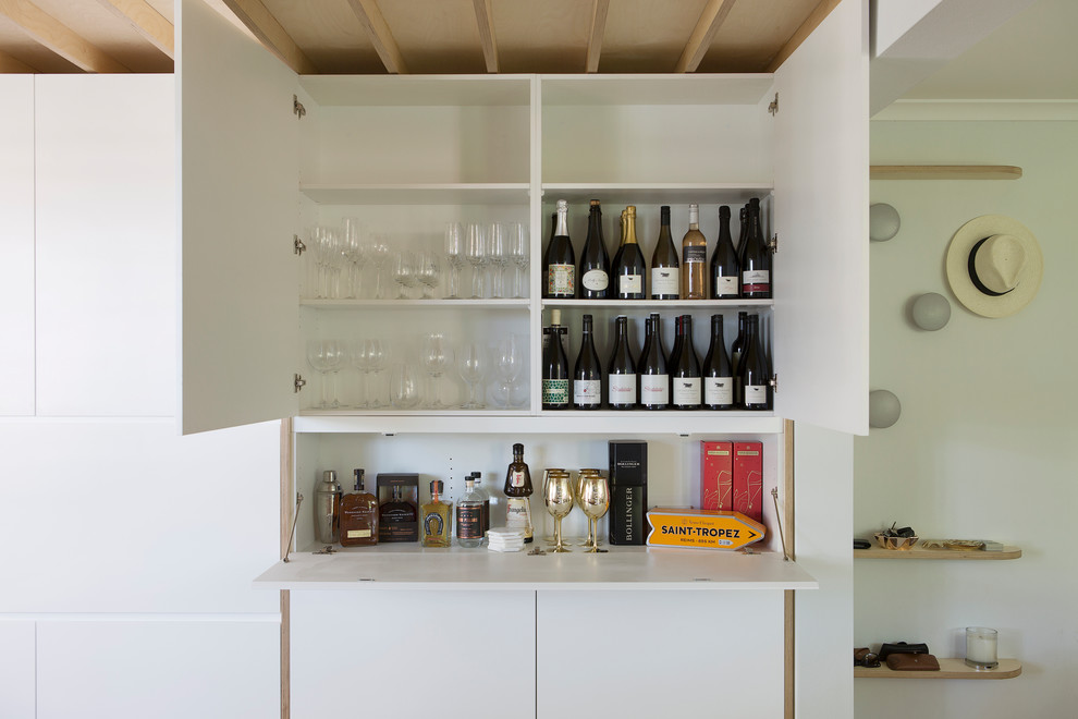 Photo of a contemporary single-wall wet bar in Sydney with flat-panel cabinets, white cabinets, white splashback and white benchtop.