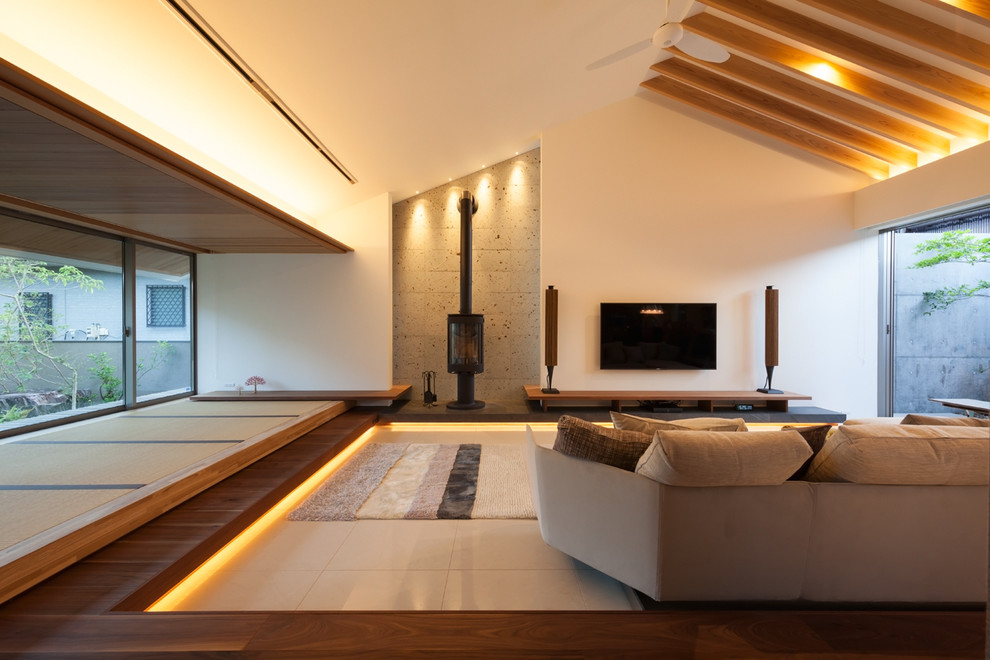 Contemporary family room in Other with white walls, a wall-mounted tv and beige floor.