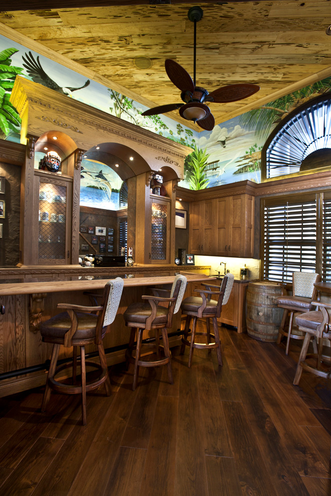 Photo of a tropical u-shaped seated home bar in Miami with dark hardwood floors, recessed-panel cabinets and dark wood cabinets.