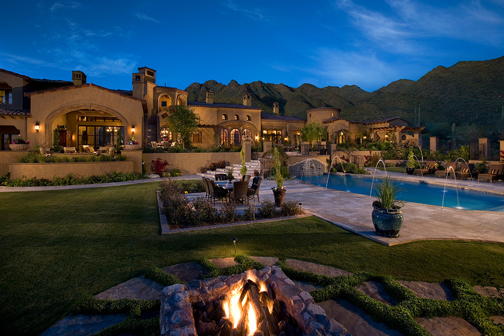 Example of a huge tuscan backyard stone and rectangular lap pool fountain design in Phoenix