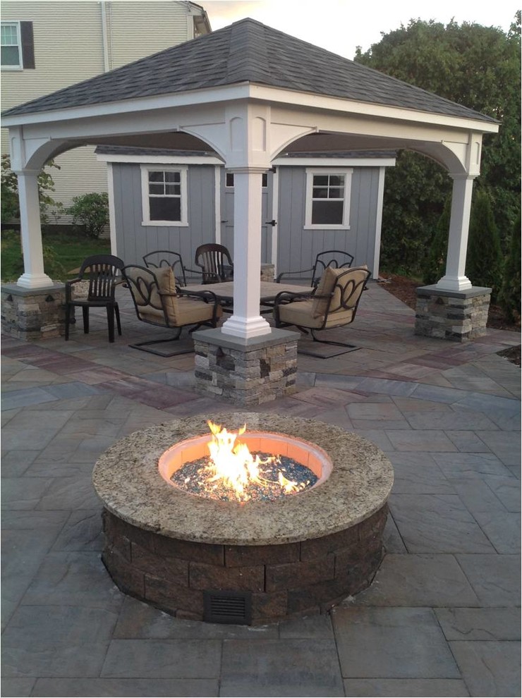 This is an example of a large traditional backyard patio in New York with a fire feature, concrete pavers and a gazebo/cabana.