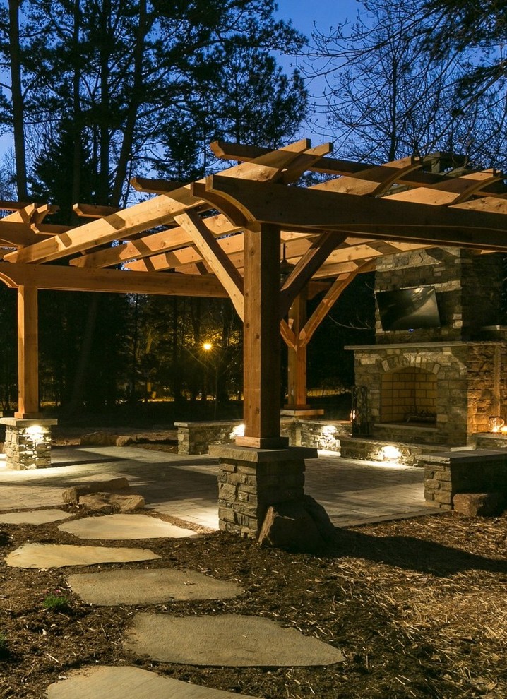 This is an example of a mid-sized arts and crafts backyard patio in Charlotte with a fire feature, concrete pavers and a pergola.